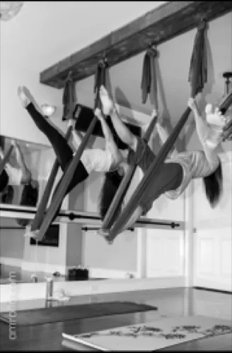Students suspended in fabric aerial yoga slings at Studio143