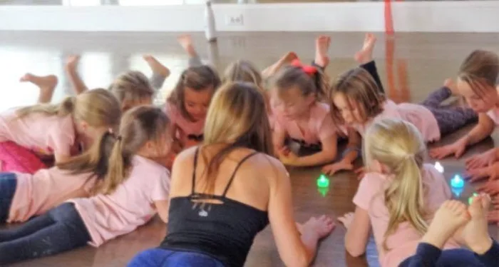 Children lying on yoga mats in a circle during a birthday party at Studio143