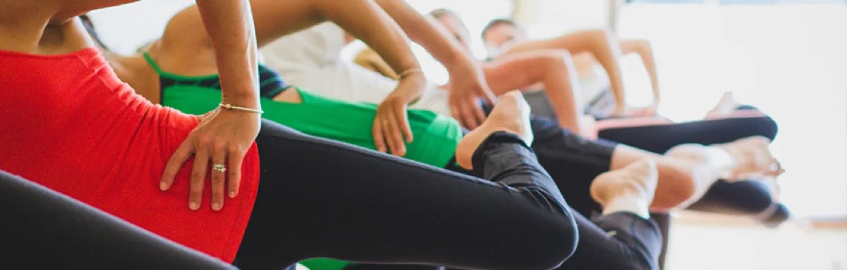 Adults stretching together during a class at Studio143